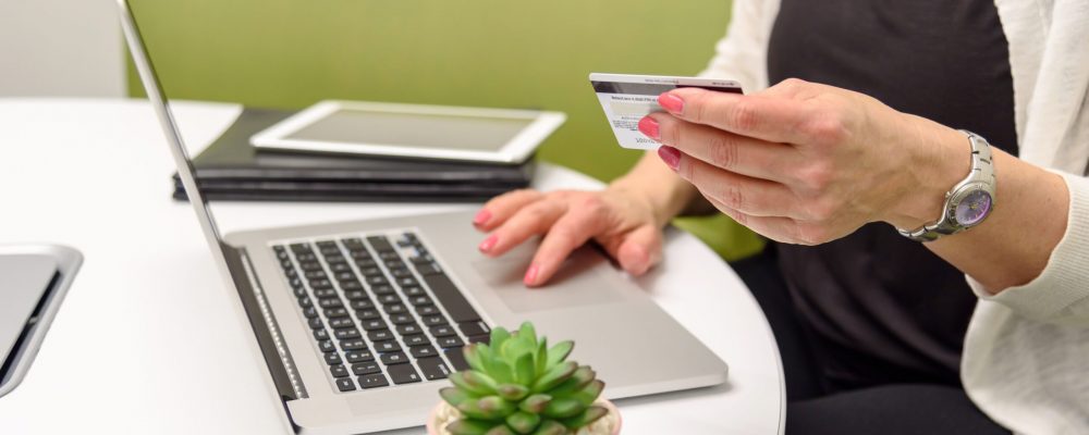Closeup,Of,A,Woman,Holdng,A,Credit,Card,At,Table