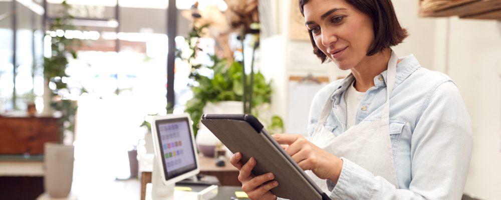 Female,Owner,With,Digital,Tablet,Standing,Behind,Sales,Desk,Of Female,Owner,With,Digital,Tablet,Standing,Behind,Sales,Desk,Of