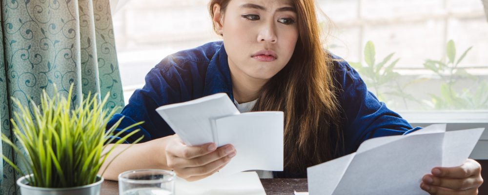 Stressed,Young,Asian,Woman,Trying,To,Find,Money,To,Pay