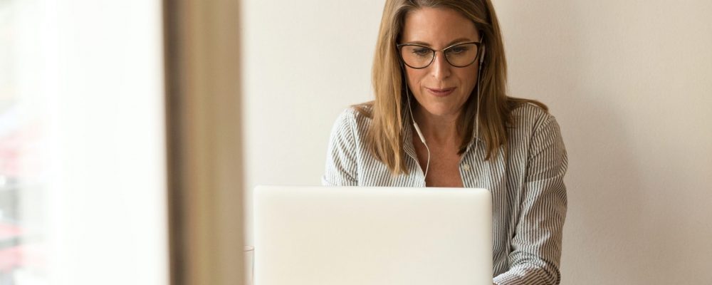 linkedin-sales-solutions-wS73LE0GnKs-unsplash Woman working on laptop in an office.
