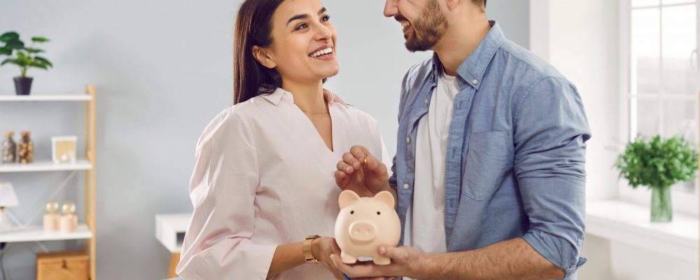 Smiling,,Happy,Young,Family,Together,Put,Coins,In,Piggy,Bank