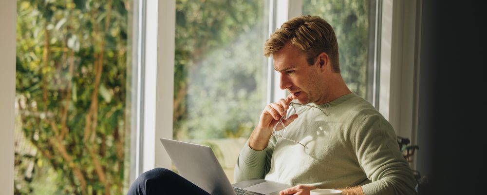 Man,Working,On,Laptop,And,Thinking.,Man,Sitting,At,Home