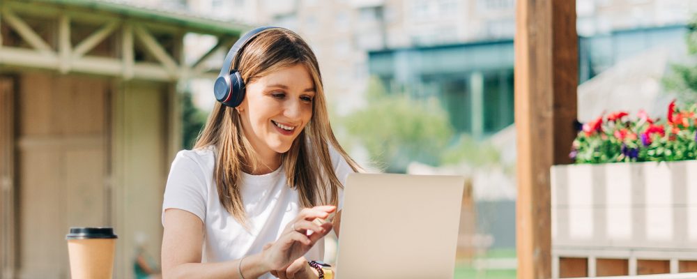 Young,Hipster,Woman,In,Headphones,Using,Laptop,,Having,A,Video